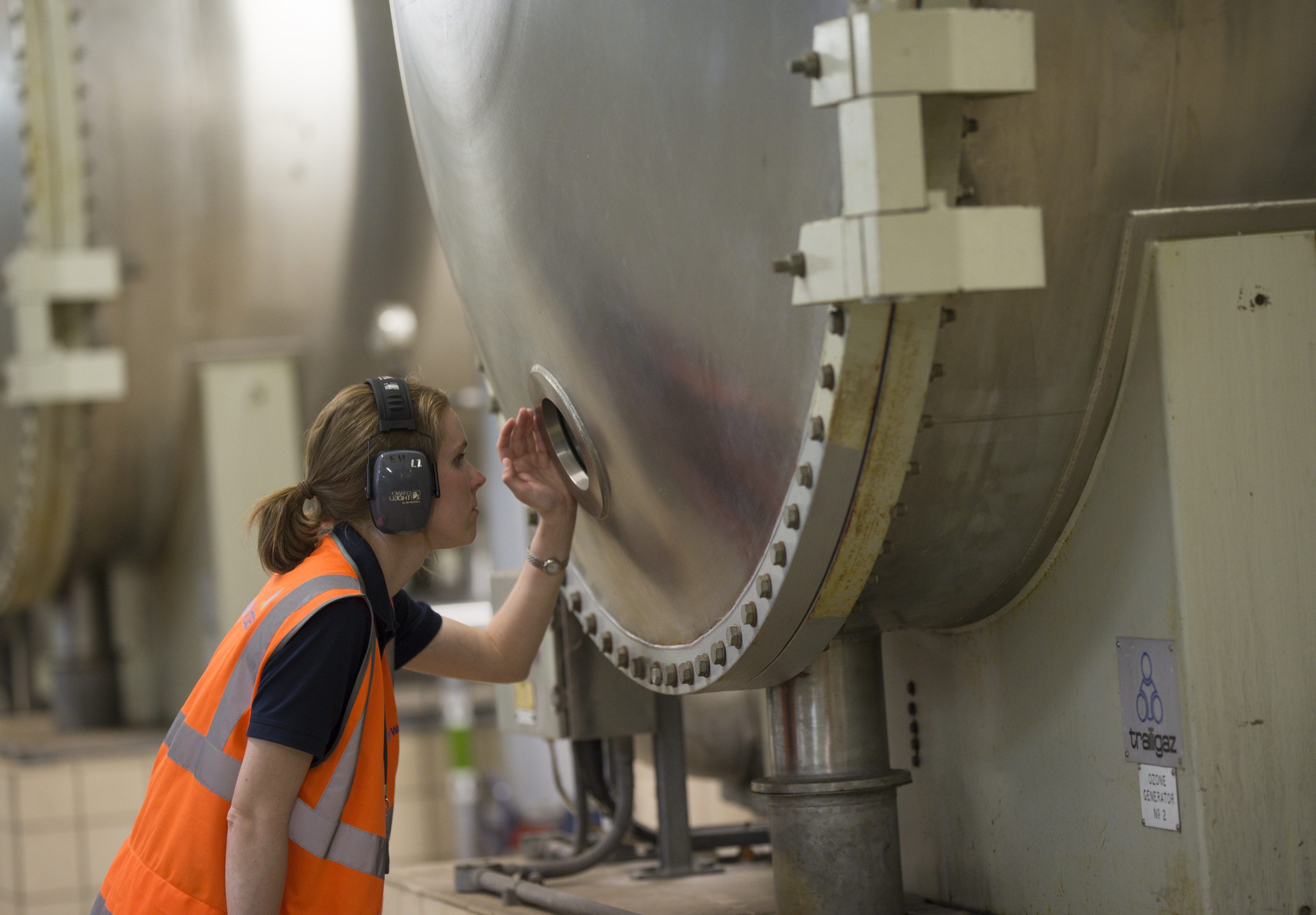 Woman checking factory machinery