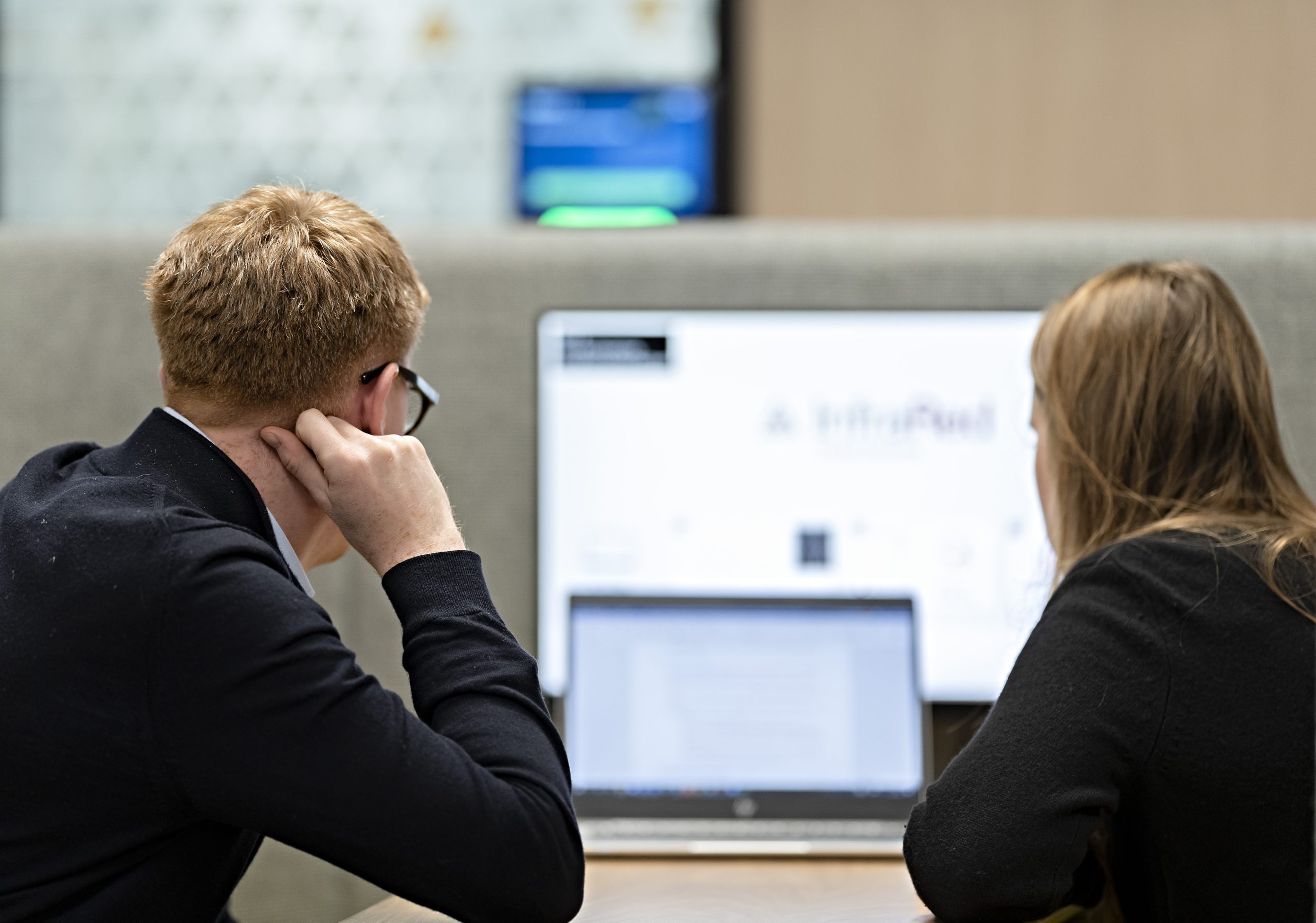 man and woman looking at computer screen
