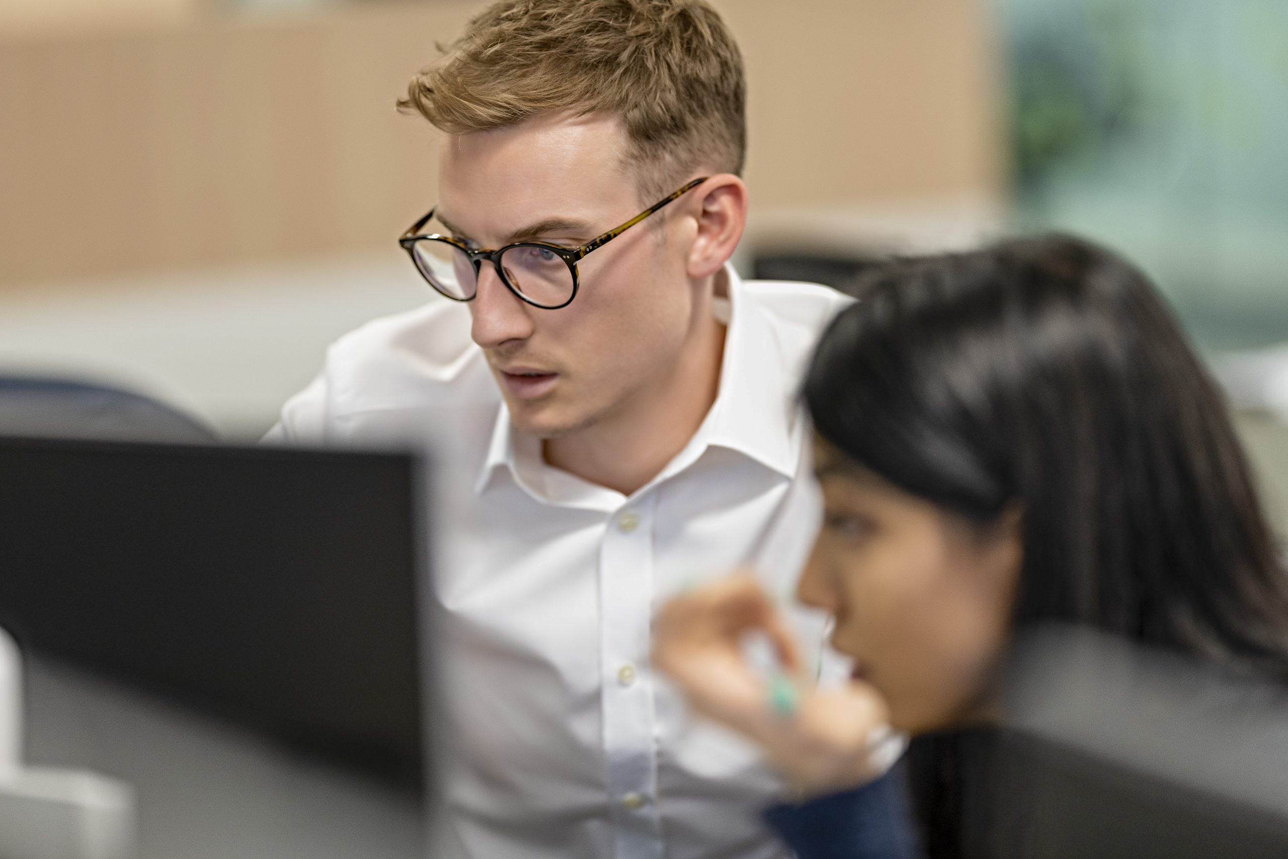 man and woman looking at screen